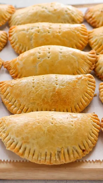 Golden baked meat pies in rows